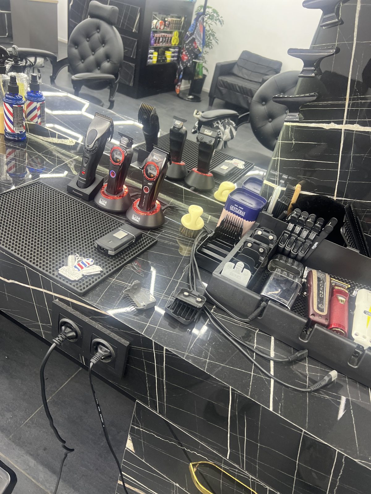 Kappersstation met tondeuses en gereedschap op zwart marmer
