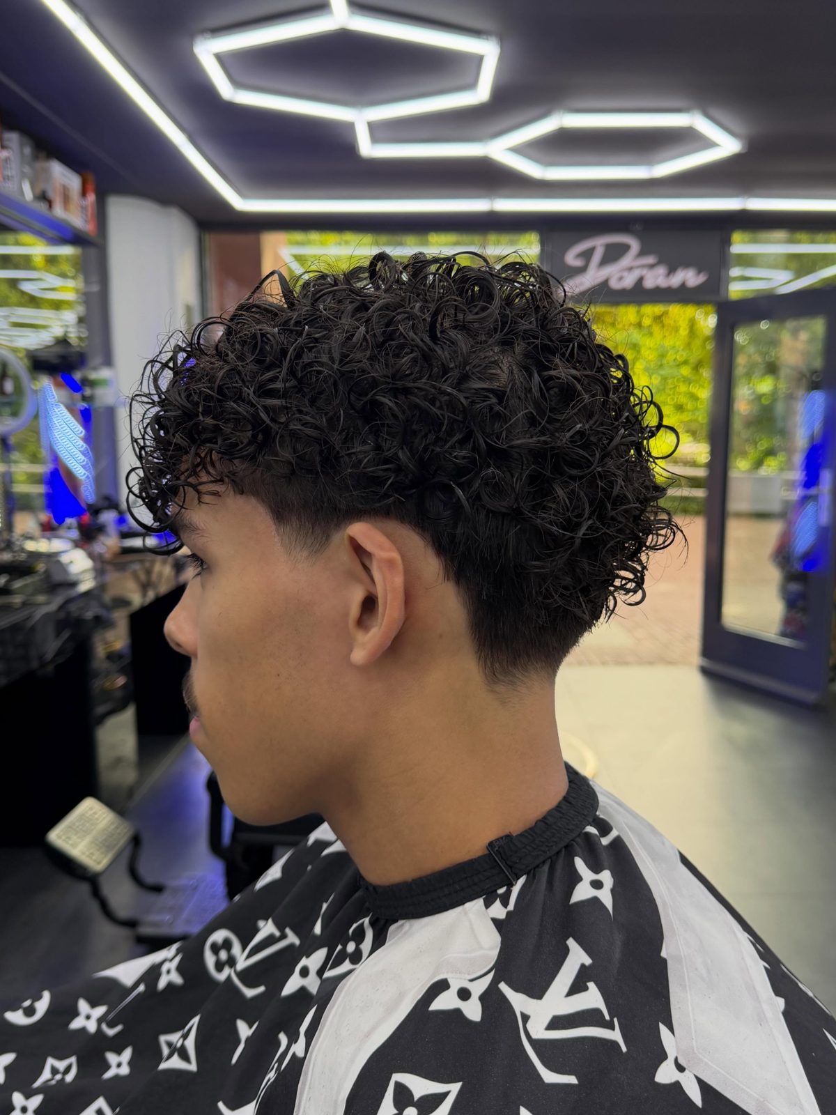 Krullend kapsel met fade, in Salon Doran